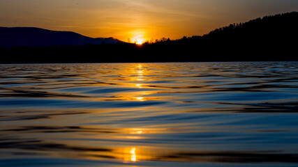 Zachodzące słonce za górami z widokiem znad jeziora / The setting sun behind the mountains overlooking the lake