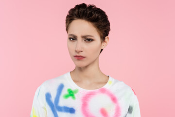 offended brunette woman with short hair looking at camera isolated on pink