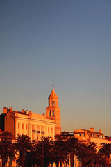 Fototapeta premium Saint Domnius bell tower and historical buildings on promenade in Split, Croatia, illuminated by beautiful golden hour light. 