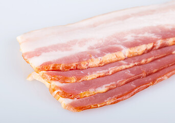 Slices of raw bacon, isolated on a white background. Close-up