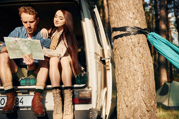 Weekend activities. Young couple is traveling in the forest at daytime together