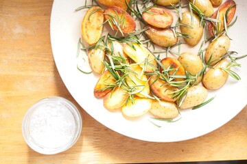 cooking fried potatoes in white pan