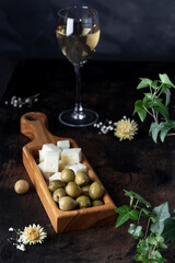 olives with homemade cheese on wooden board