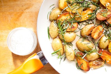 cooking fried potatoes in white pan
