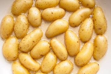 cooking fried potatoes in white pan