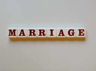 The word Marriage spelled with white and red tiles