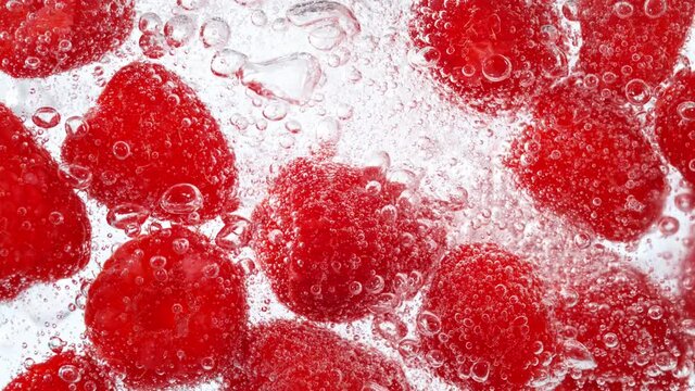 Super Slow Motion Shot of Fresh Raspberries with Sparkling Water and Ice Cubes, Home Made Lemonade. Filmed on high speed cinema camera at 1000fps.