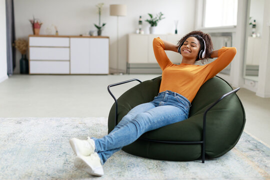 Calm black woman having rest at home on bean bag