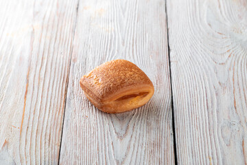 Freshly baked tasty bun on a white wooden table. Tasty baked goods straight from the bakery. White...