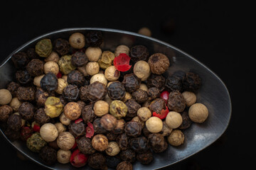Various colored pepercorns on a dark background