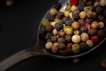 Various colored pepercorns on a dark background