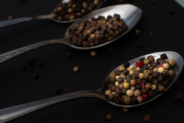 Various colored pepercorns on a dark background