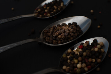 Various colored pepercorns on a dark background