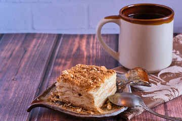 Homemade baked cake Napoleon, Millefeuille. Delicate custard cake. Against the background of a wooden table with a beautiful napkin.