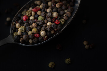 Various colored pepercorns on a dark background