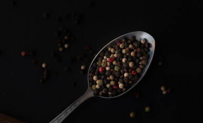 Various colored pepercorns on a dark background