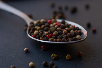 Various colored pepercorns on a dark background
