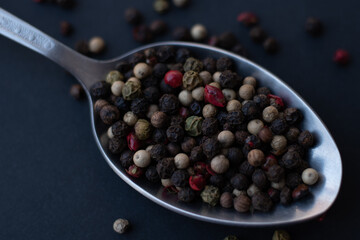 Various colored pepercorns on a dark background
