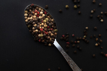 Various colored pepercorns on a dark background