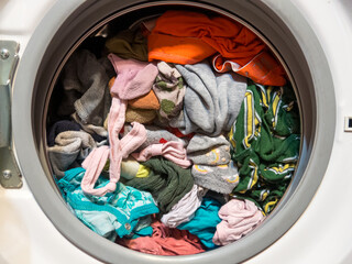 man puts clothes in the washing machine, close-up