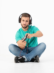Man playing videogames with a controller and a headphones in a white background