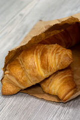 Freshly baked croissants in a brown paper bag.  Recycle plastic free packaging concept