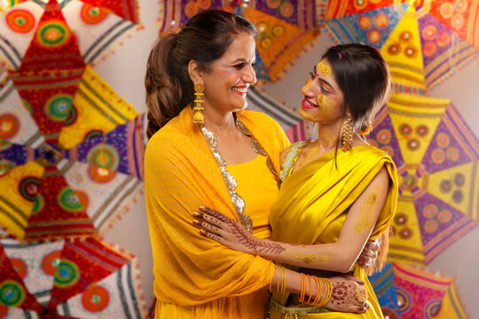 Portrait of Mother and daughter looking each other during haldi ceremony
