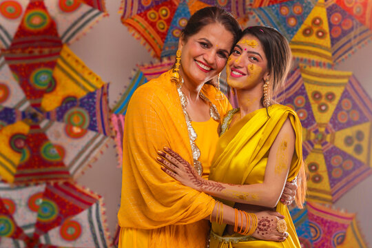Portrait of Mother and daughter looking at camera during haldi ceremony