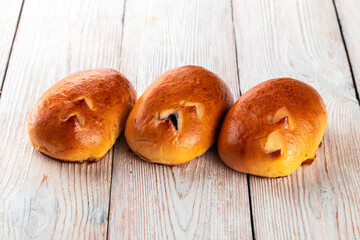 Freshly baked tasty bun on a white wooden table. Tasty baked goods straight from the bakery. White...