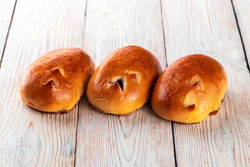 Freshly baked tasty bun on a white wooden table. Tasty baked goods straight from the bakery. White...