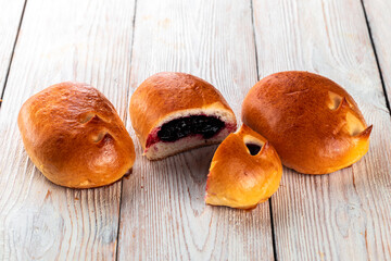 Freshly baked tasty bun on a white wooden table. Tasty baked goods straight from the bakery. White...