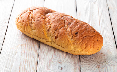 Freshly baked tasty bun on a white wooden table. Tasty baked goods straight from the bakery. White background.