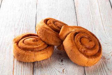 Freshly baked tasty bun on a white wooden table. Tasty baked goods straight from the bakery. White...