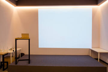 
empty room with white frame projector screen and lecturer area
