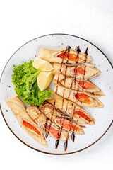 Pancakes stuffed with red caviar and salmon.  Russian dish. Isolated on a white background. Top view