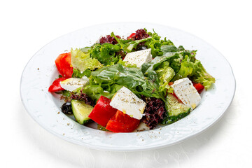 Greek salad with fresh vegetables and feta cheese. Isolated on a white background