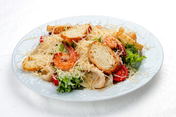 Caesar salad with seafood, egg and fresh vegetables. Isolated on a white background