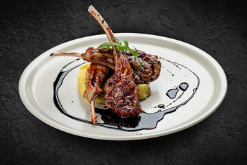 Rack of lamb with couscous with cherry sauce. Isolated on a black background