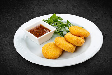 Fried suluguni with honey mustard sauce. Isolated on a black background.