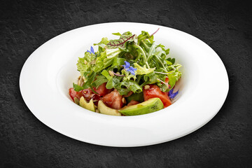 Salad with avocado and pine nuts. Isolated on a black background.