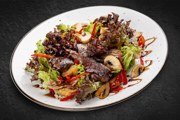 Salad with chicken liver, sweet pepper and champignons. Isolated on a black background.
