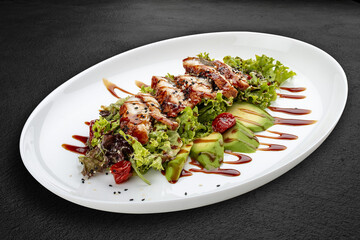 Salad with eel and avocado . Isolated on a black background.