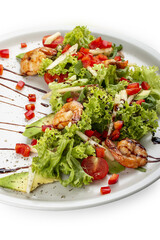 Salad with avocado and tiger prawns, seasoned with pesto sauce. Isolated on a white background.
