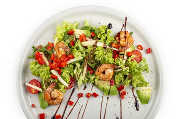 Salad with avocado and tiger prawns, seasoned with pesto sauce. Isolated on a white background.