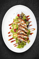 Salad with eel and avocado . Isolated on a black background.