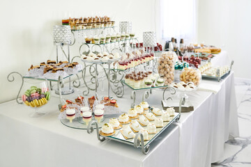 Wedding candy bar with desserts on the table. Buffet with delicious bakery