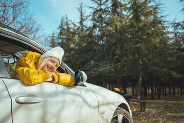 Cropped shot of an attractive woman hanging out of a car window while enjoying a road trip. Road trips put me in a happy mood. Young girl enjoying a road trip.