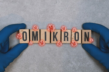 Omikron Corona Virus Variante Holzbuchstaben mit Schutzhandschuhen und Corona Viren