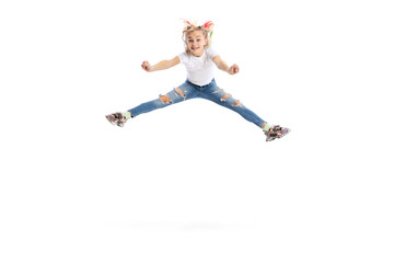 Fototapeta na wymiar Emotional beautiful little girl, kid in casual clothes jumping, having fun isolated on white studio background.