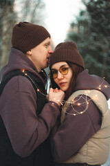 A couple in love embraces in winter in a snow-covered forest